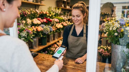 Floristin nimmt eine kontaktlose Kartenzahlung direkt am Smartphone an